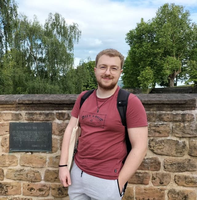 Alvaro next to a Robin Hood plaque
